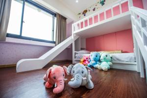 un grupo de elefantes disecados en una habitación con litera en Red hotel, en Yuanlin