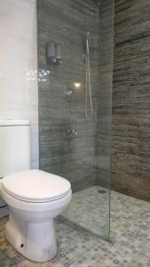 a bathroom with a toilet and a glass shower at Escotel Villa Marga in Tabanan