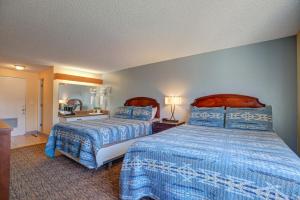 a hotel room with two beds with blue comforter at Columbia Gorge Inn in Cascade Locks