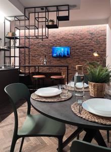 a dining room with a table and chairs and a brick wall at Plebiscito Old Fashion in Castel di Sangro