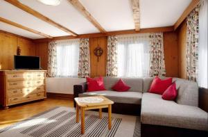 uma sala de estar com um sofá e almofadas vermelhas em Allgäuer Stube em Oberstaufen