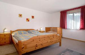 um quarto com uma cama de madeira e uma janela em Allgäuer Stube em Oberstaufen