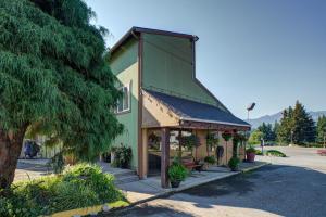 a green building with a bench in front of it at Columbia Gorge Inn in Cascade Locks