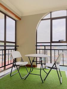 einen Tisch und zwei Stühle in einem Zimmer mit Fenstern in der Unterkunft LEYSHOF HOTEL in Mwanza