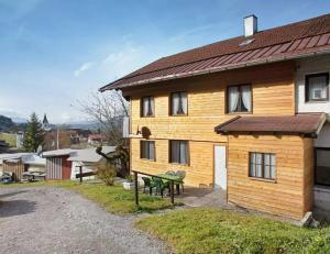 una casa de madera con un banco verde delante de ella en Allgäuer Stube, en Oberstaufen