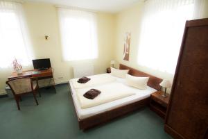 um quarto com uma cama, uma secretária e janelas em Hotel Namaste India em Piesteritz