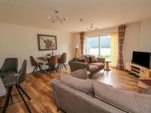 a living room with a couch and a television and a table at Lochy Lookout in Spean Bridge