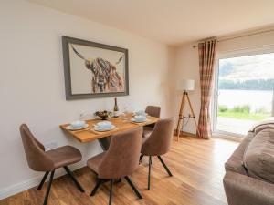 comedor con mesa, sillas y sofá en Lochy Lookout en Spean Bridge