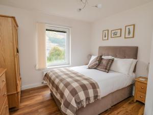 1 dormitorio con cama y ventana en Lochy Lookout, en Spean Bridge