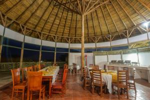 a restaurant with tables and chairs and a large umbrella at Tilenga Safari Lodge in Arua