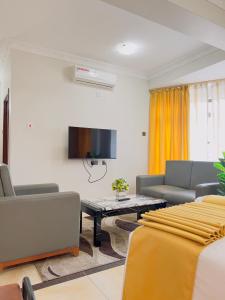 a living room with a couch and a tv at LEYSHOF HOTEL in Mwanza