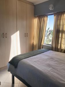 a bedroom with a bed and a large window at Daffodil self catering and accommodation A in Swakopmund
