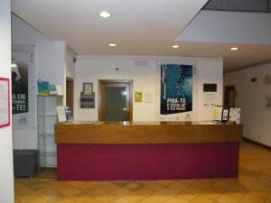 a lobby with a counter with a poster on the wall at HI Ofir – Pousada de Juventude in Esposende