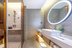 a bathroom with a sink and a mirror at Atour Hotel Yibin West Railway Station in Yibin +14 photos