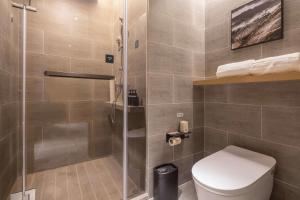 a bathroom with a toilet and a glass shower at Atour Hotel Nantong Jinsha in Nantong
