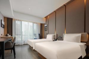 a hotel room with two beds and a desk at Atour Hotel Zezhou Road Jincheng in Jingcheng
