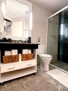 a bathroom with a toilet and a glass shower at São Paulo Moema Times Square - Suite LUXO in Sao Paulo