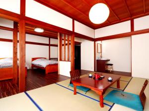 a living room with a table and a bed at 富山県 よしのや旅館 in Nanto