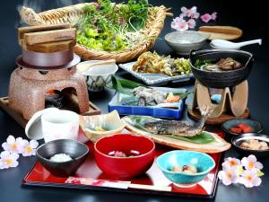 a table topped with bowls and plates of food at Yoshinoya Ryokan in Nanto