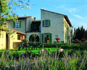 a house with a table and chairs in a garden at Podere Il Pino in Poggibonsi