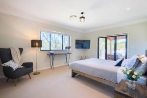 een slaapkamer met een bed, een bureau en een stoel bij Alleura House Serene Bushland 4BR Families Groups in Leura