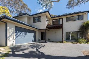 a large white house with a garage at Alleura House Serene Bushland 4BR Families Groups in Leura