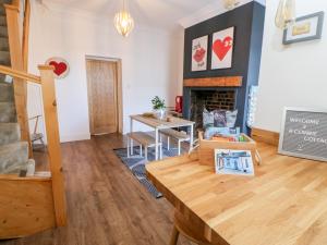 a living room with a table and a fireplace at Cowrie Cottage in North Shields