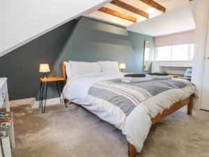 a bedroom with a large bed with a blue wall at Cowrie Cottage in North Shields