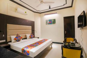 a bedroom with a bed and a desk and a television at FabHotel NV in Gurgaon