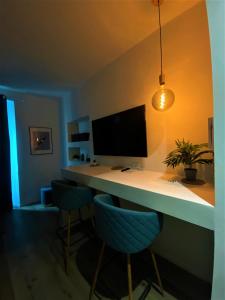 escritorio con monitor de ordenador y 2 sillas azules en - La Casa delle Meraviglie- Porta Romana Edition, en Milán
