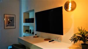 uma televisão de ecrã plano pendurada numa parede em - La Casa delle Meraviglie- Porta Romana Edition em Milão