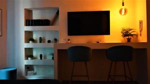 escritorio con 2 sillas y TV en la pared en - La Casa delle Meraviglie- Porta Romana Edition, en Milán