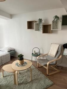uma sala de estar com um sofá, uma cadeira e uma mesa em Studio Hyères -Rue piétonne Climatisation lit 160 tout équipé - Sabrina em Hyères