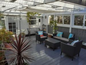 een patio met banken en stoelen op een veranda bij The Treehouse by Airlie in Nairn
