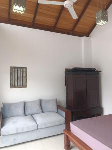 ein Wohnzimmer mit einem Sofa und einer Holzdecke in der Unterkunft Villa Suyara Rooftop,,, in Panadura