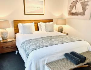 una camera da letto con un grande letto bianco con due lampade di The Waterfront Apartment a Port Fairy