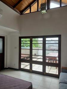 a bedroom with sliding doors with a view of a patio at Villa Suyara Rooftop,,, in Panadura