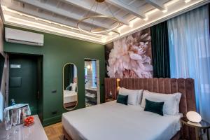 ein Schlafzimmer mit einem großen Bett und einer grünen Wand in der Unterkunft Palazzetto Trevi in Rom
