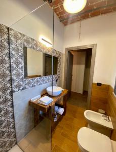 a bathroom with a sink and a toilet and a mirror at Cascina Mora Bassa in Vigevano