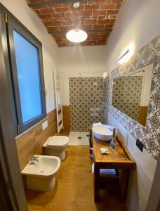 bagno con 2 servizi igienici, lavandino e specchio di Cascina Mora Bassa a Vigevano