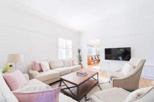 a living room with a couch and chairs and a tv at La Villette sleeps 9 fireplace BBQ Pet Friendly in Katoomba