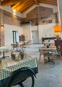 Cette chambre est dotée de tables, de chaises et d'un mur en briques. dans l'établissement Cascina Mora Bassa, à Vigevano