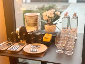 - une table avec des assiettes, des fourchettes et des verres à vin dans l'établissement Cascina Mora Bassa, à Vigevano