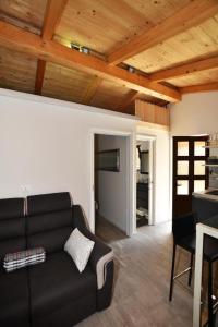 un salon avec un canapé noir et une cuisine dans l'établissement Deluxe Apartment Nono- Anex building, à Poreč