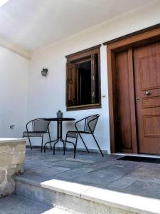 un tavolo e sedie accanto a una porta in legno di Παραδοσιακή κατοικία-Παλιά Πόλη a Tríkala