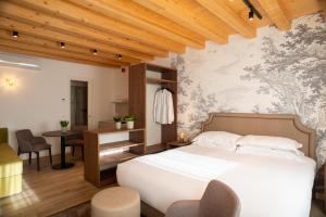 1 dormitorio con 1 cama, mesa y sillas en Relais La Dolce Vite, en San Vendemiano
