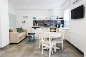 a kitchen and living room with a table and chairs at MYKONOS APARTMAN in Makó