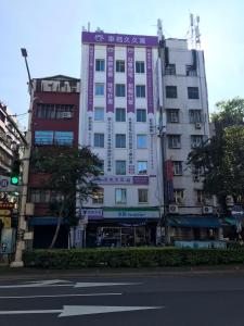 台北市にあるPuremeworld Hotelの紫色のアクセントが施された高層ビル