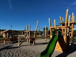 un parque infantil con un tobogán verde en Sonnenthermen Chalets & Therme included - auch am An- & Abreisetag!, en Lutzmannsburg