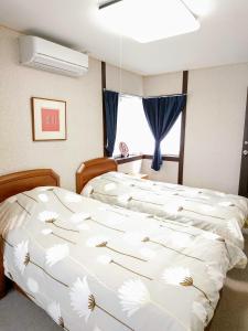 a bedroom with two beds and a window at Homestay Intimo Amigo in Tokyo
